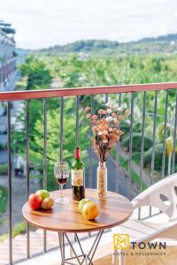 富国Luxy Park Hotel & Apartments - MTown的一张桌子,上面放着一瓶葡萄酒和一杯