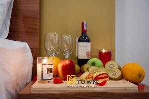 富国Luxy Park Hotel & Apartments - MTown的一张桌子,上面放着一瓶葡萄酒、水果和玻璃杯