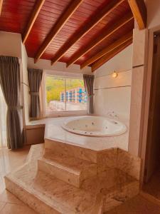 拉维加Juan de la vega的一间带窗户的客房内设有带浴缸的大浴室