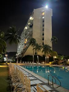 波德申Seafront38&39 - Regency Tg Tuan beach resort, port dickson的一座高大的建筑,晚上有游泳池