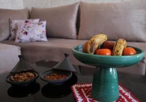 马拉喀什appartement confort calme propre的一张沙发桌子上的一碗绿色水果