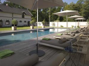 蒙蒂尼雷斯雷斯酒庄 - 设计酒店的游泳池旁的一排躺椅和遮阳伞