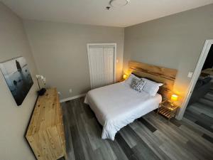 圣约翰Premium 2-bed Condo Uptown Saint John Parking Coffee Location的卧室配有白色的床,铺有木地板