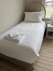 墨尔本Rodonia - Cottage in Kew的一张带白色床单和枕头的床