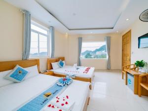 吉婆岛Làng Chài Hotel & Restaurant的酒店客房设有两张床和窗户。