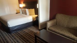 亨博尔Red Roof Inn & Suites Houston – Humble/IAH Airport的酒店客房,配有床和沙发