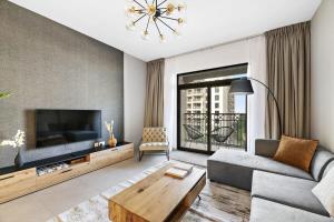 迪拜Silkhaus newly furnished 1BDR next to Burj Al Arab的带沙发和电视的客厅