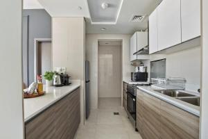 阿布扎比Silkhaus Al Reem island Modern 1BDR的一间大厨房,配有白色的橱柜和水槽