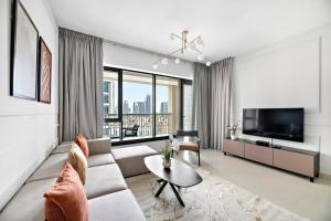 迪拜Silkhaus chic 1BDR with patio near Burj Khalifa的带沙发和电视的客厅