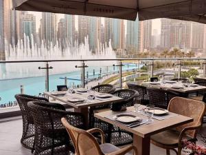 迪拜Silkhaus chic 1BDR with patio near Burj Khalifa的一间带桌椅的餐厅和一个喷泉