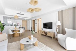 阿布扎比Silkhaus Premium Luxury Unit by Aldar with Beach Access的带沙发、电视和桌子的客厅