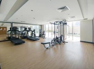 阿布扎比Silkhaus New Pad with Pool & Gym near Reem Mall的健身房设有数台跑步机和椭圆机