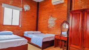 Tân PhúHOMESTAY HƯƠNG RỪNG的一间设有两张床和镜子的房间