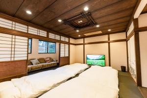 雾岛市La Saison Inn Kirishima 888的木制天花板的客房内的一张大床