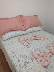 佩洛塔斯Casa em Condomínio Fechado的床上有两双粉色鞋