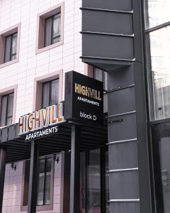 阿斯塔纳HIGHVIL APARTAMENTS的前面有两个标志的建筑