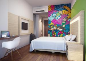 丹戎潘丹贝尔斯塔贝腾酒店的卧室配有白色的床和墙上的绘画作品