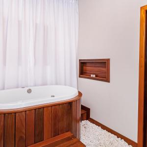 皮雷诺波利斯Pousada Vila Rica的带浴缸的浴室和窗户。