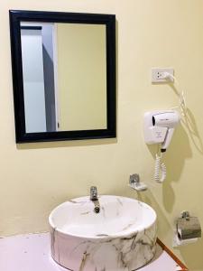 南府Three Bridges Hotel的浴室设有白色水槽和镜子