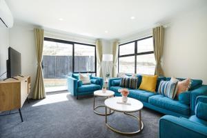 汉密尔顿Charming 4bds House with 3 bathrooms Brand New的客厅配有蓝色的沙发和电视