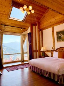 仁爱乡清境珂之幄山庄 的一间卧室设有一张床和一个大窗户