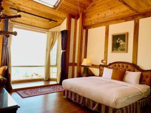 仁爱乡清境珂之幄山庄 的一间卧室设有一张床和一个大窗户