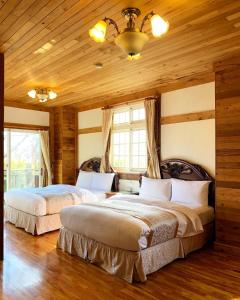 仁爱乡清境珂之幄山庄 的卧室设有两张床,配有木墙和木地板