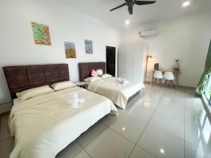 新山Desaru 20Pax Cozy Chill villa Private Pool的白色墙壁客房的两张床