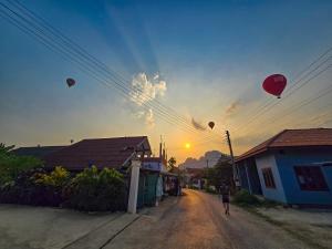 万荣Saphaothong guesthouse的天上带着气球沿着土路走的人