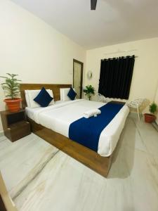 商沙巴Hotel KP Suites Airport的一间卧室配有一张带蓝白色床单的大床