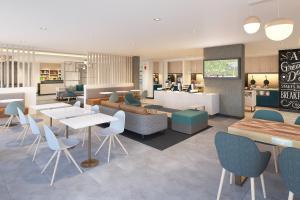 GenevaTownePlace Suites by Marriott Geneva at SPIRE Academy的自助餐厅内带桌椅的餐厅
