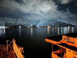 斯利那加新杰奎琳遗迹船屋酒店的享有湖泊和山脉的夜间美景