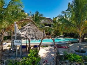 江比阿Villa Juliana的一个带游泳池和棕榈树的度假村