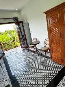 Phong ÐiềnRạch sao eco garden的一间设有桌子和两把椅子的房间和一扇门
