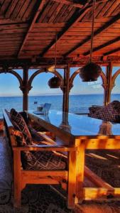 达哈布幻影村酒店的屋顶下木桌子和椅子,享有海景