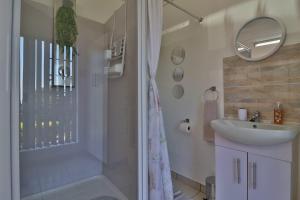 内尔斯普雷特Sleep Haven Self-Catering Accommodation - Nelspruit的带淋浴、盥洗盆和镜子的浴室