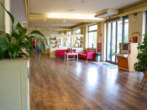 佩斯卡拉丽晶特酒店的大型客房,铺有木地板,配有粉红色的家具。