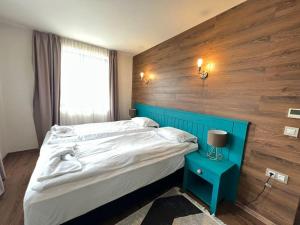 多布里尼什特Villa in Ruskovets Resort的一间卧室配有一张大床和蓝色床头板