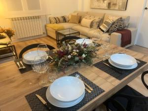 萨拉戈萨Capricho Lostal的客厅配有带盘子和玻璃杯的桌子