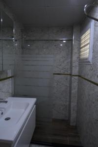 帕莫卡莱YILDIZHAN HOTEL的白色的浴室设有水槽和淋浴。