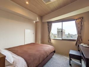 宇部宇部市新盖亚酒店的一间卧室设有一张大床和一个窗户。