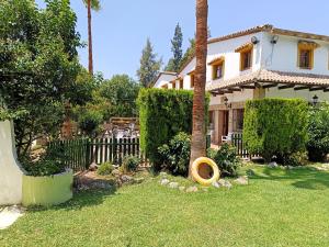 El ColmenarHotel Restaurante Las Buitreras的院子中带栅栏和树的房子