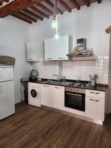 吉廖港ANCORA GIGLIO home的厨房配有白色橱柜、水槽和洗碗机。