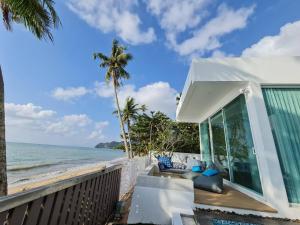 Ban Thung MakhamLuxtalay beachhouse villa的海滩上一棵棕榈树的房子