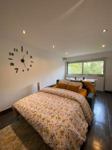 格拉斯Grasse - Free Parking - Pool的卧室配有一张床,墙上挂着一个钟