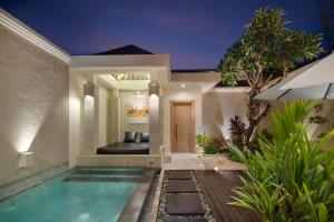 塞米亚克The Seiryu Boutique Bali Villas的夜间带游泳池的别墅