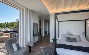 Petit Cul de SacLuxury Vacation Villa 21的一间带大床的卧室和一个阳台