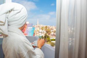 卡萨布兰卡肯兹巴斯马酒店的一位头巾中的女人,看着窗外的城市