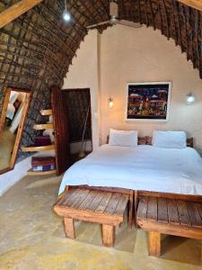 姆巴巴内Hawane Resort的一间卧室配有床和两张木制长椅