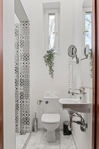 布加勒斯特Nest Boutique Hostel的白色的浴室设有卫生间和水槽。